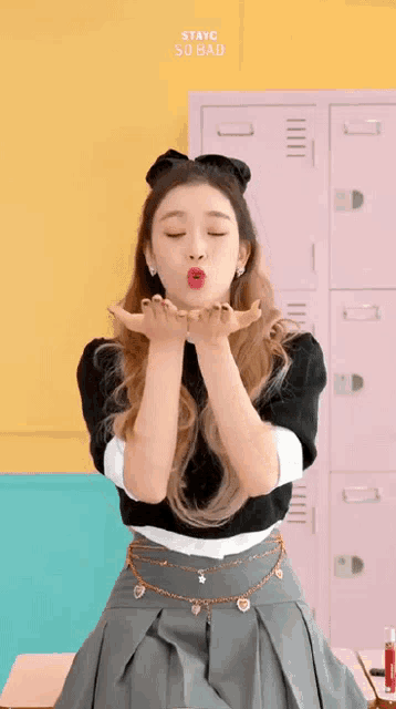 a girl blowing a kiss with the words stayc so bad above her head
