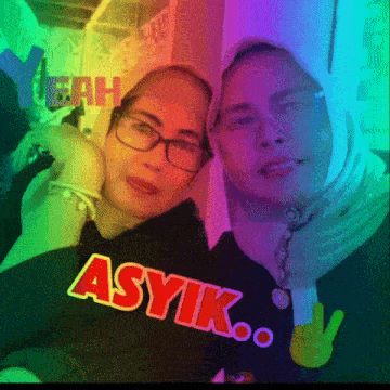 two women standing next to each other with the word asyik on their shirt