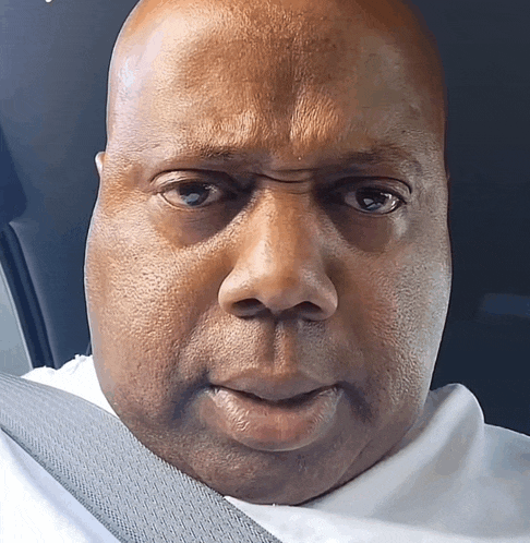 a close up of a man 's face with a seat belt on