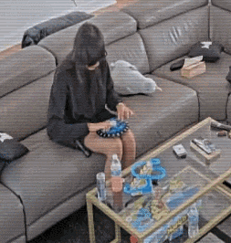 a woman is sitting on a couch in front of a glass table .