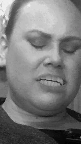 a woman 's face is shown in a black and white photo with her eyes closed