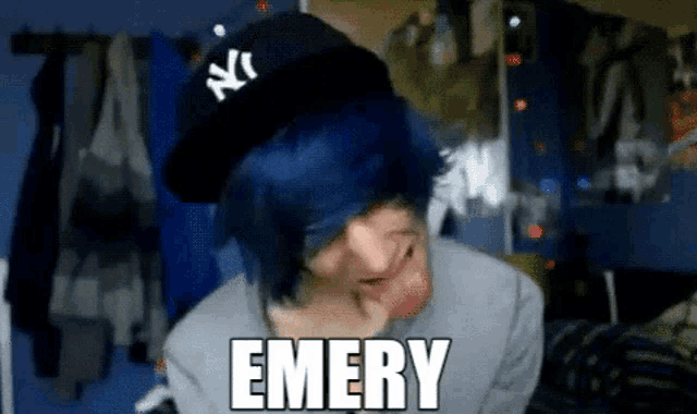 a person with blue hair wearing a ny hat with the word emery written on it