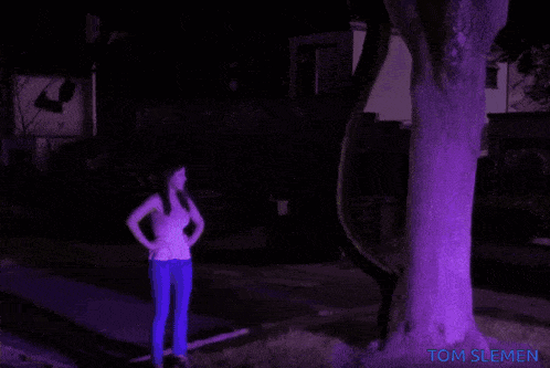 a woman is standing in front of a house with the name tom slemen on the bottom