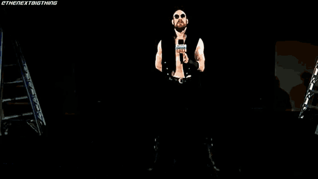 a wrestler named aiden english stands in front of a microphone