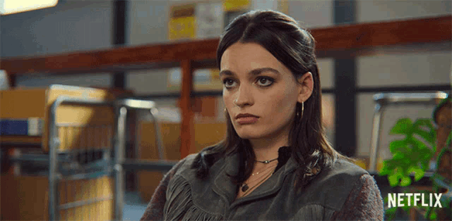 a woman is sitting in front of a sign that says " netflix "