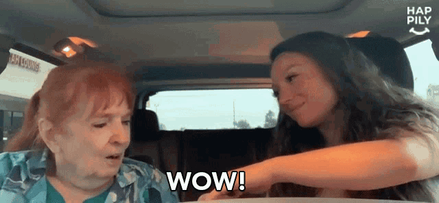 two women are sitting in a car and one is saying wow