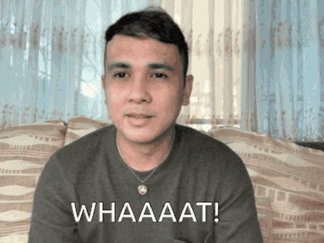 a man is sitting on a couch with the words whaaaat written on his face