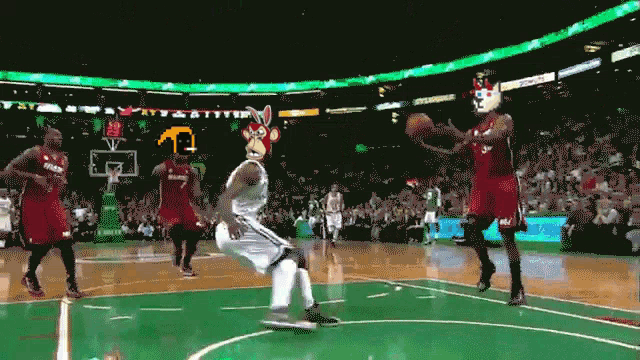 a basketball player wearing a bunny mask tries to block a shot by another player