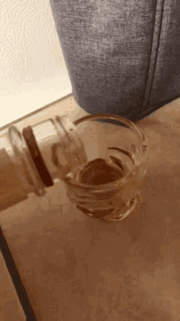 a glass of liquid is being poured from a bottle into a glass .