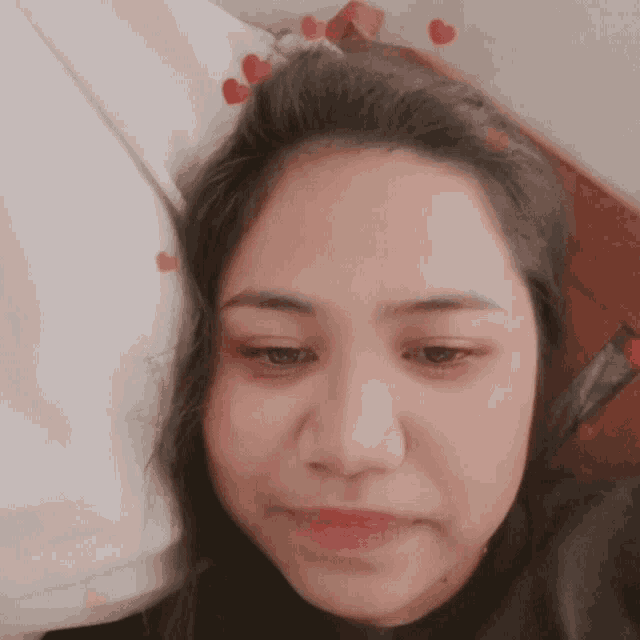 a close up of a woman 's face with hearts on her head