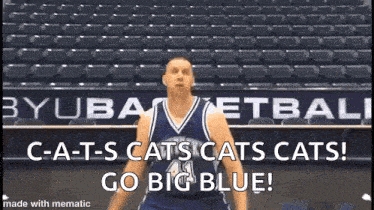 a man in a basketball uniform is standing in front of an empty stadium and shouting .