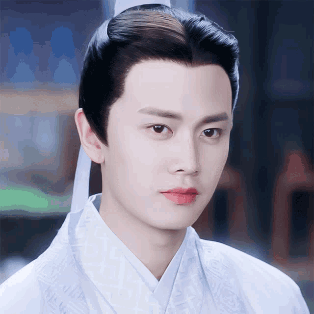 a close up of a man 's face wearing a white shirt