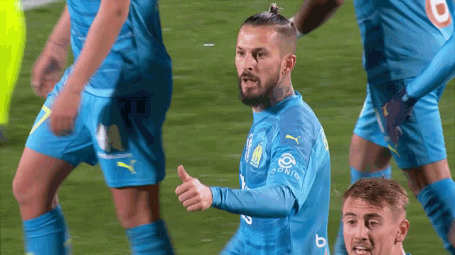 a soccer player giving a thumbs up while wearing a shirt that says domino