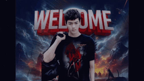 a man in a black shirt is standing in front of a welcome sign