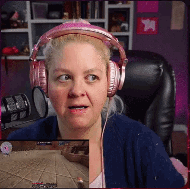 a woman wearing pink headphones looks at a screen that says minecraft