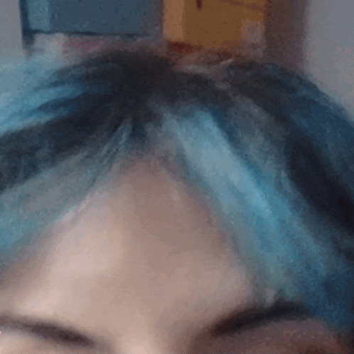 a person with blue hair has their eyes closed