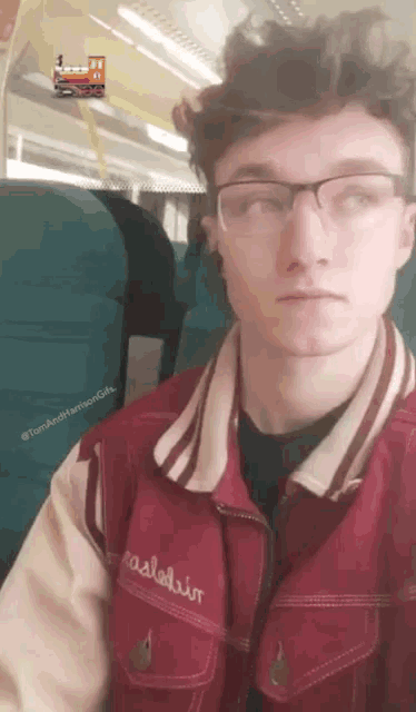a young man wearing glasses and a red jacket that says ' dale ' on it