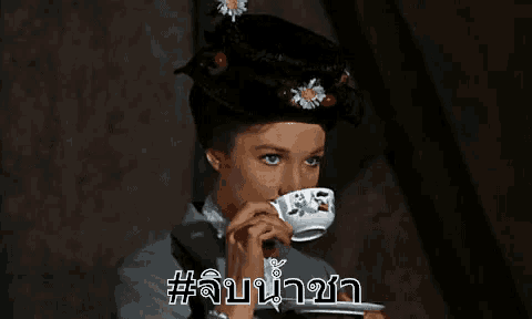 a woman is holding a cup of tea in her hand and drinking from it .