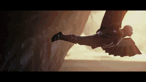 a man in a superhero costume is flying in the air