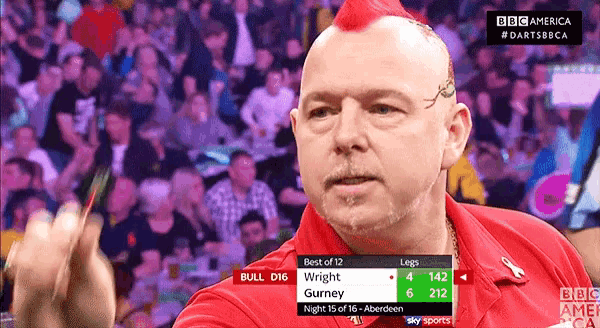 a man with a red mohawk is holding a dart in front of a crowd with a bbc america logo on the bottom right