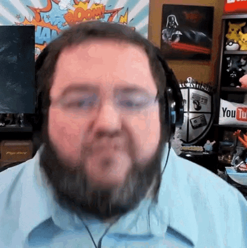 a man with a beard is wearing headphones and looking at the camera ..