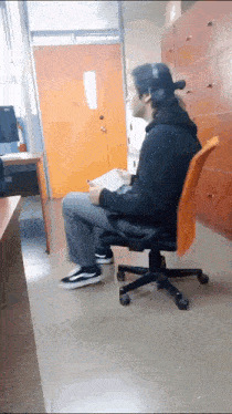 a man wearing headphones sits in an orange chair