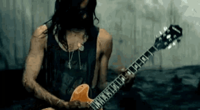 a man wearing a mask is playing an electric guitar .