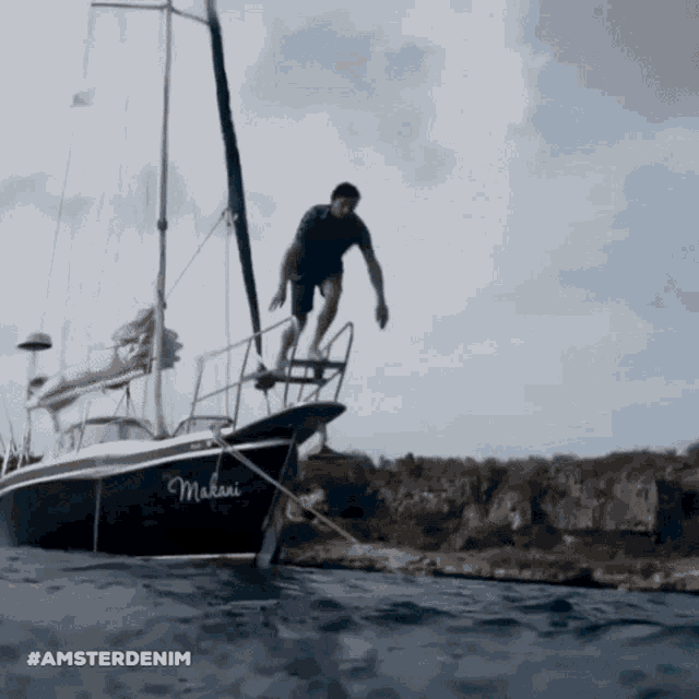 a man jumps off a boat that says makani on it