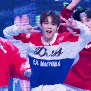 a man in a red , white and blue sweater with the word diva on it is dancing on a stage .