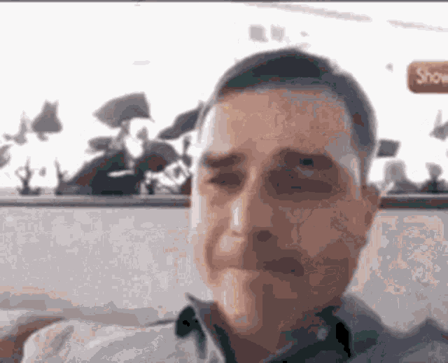 a close up of a man 's face with a blurred background of people .