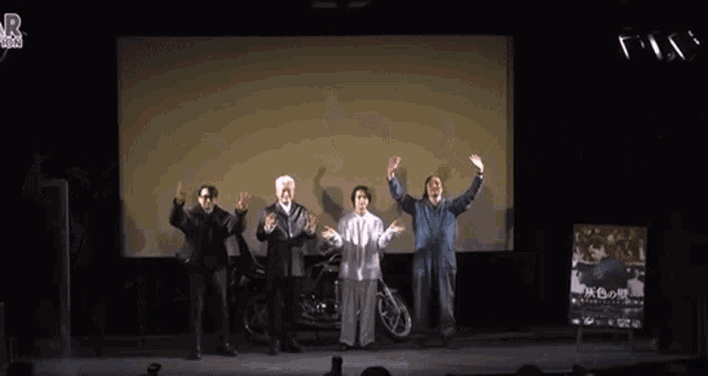 a group of people standing on a stage with their hands in the air in front of a sign that says r.vision