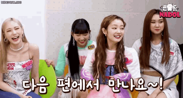 a group of girls are sitting next to each other and laughing in a room .
