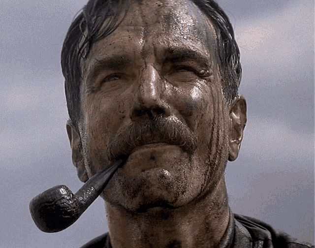 a man with a pipe in his mouth has a dirty face