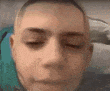 a close up of a person 's face with their eyes closed and a blurry background .