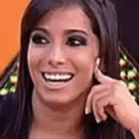 a close up of a woman 's face smiling and touching her face .