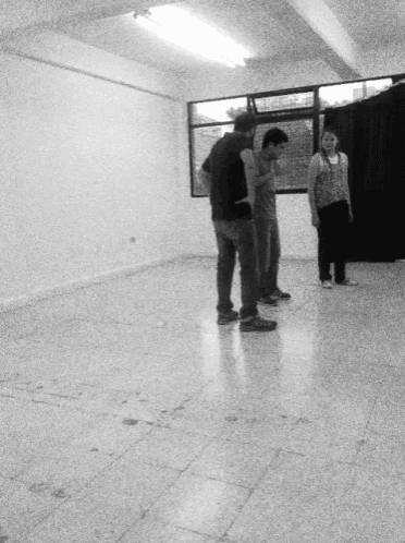 a group of people standing in a room with a black curtain