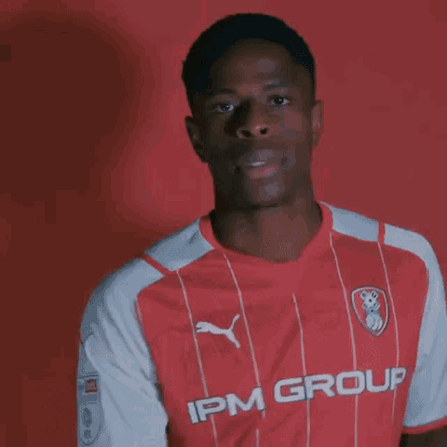 a young man wearing a red and white striped ipm group shirt