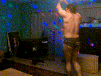 a shirtless man is dancing in a living room with disco lights