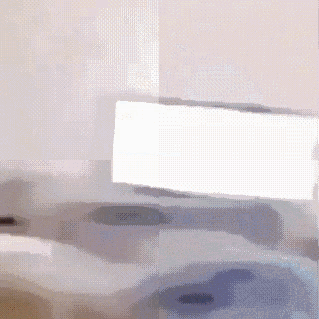 a blurred image of a room with a computer screen in the background