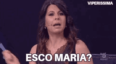 a woman in a black dress is talking into a microphone and says esco maria ?