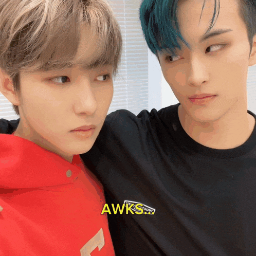 two young men are standing next to each other and one of them has a shirt that says awks