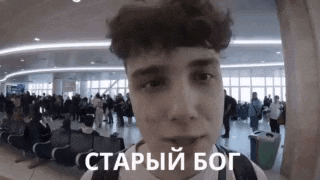 a young man is standing in front of a crowd of people in an airport .