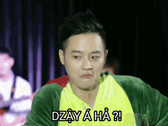 a man wearing a green and yellow jacket with the words dzay a ha on it
