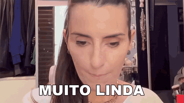 a woman in front of a mirror with the words muito linda on her face