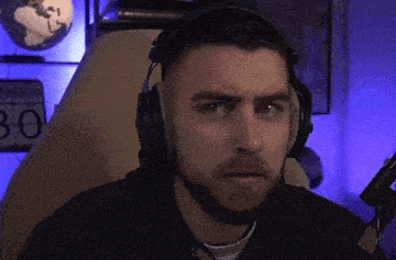 a man with a beard is wearing headphones and a microphone in front of a microphone .