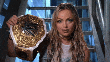 a woman is holding a gold and silver wrestling championship