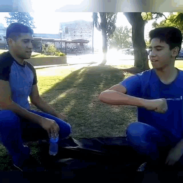 a man in a blue shirt is sitting next to another man in a black shirt
