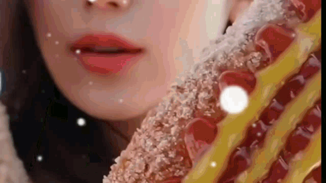 a close up of a woman 's face eating a waffle covered in powdered sugar .