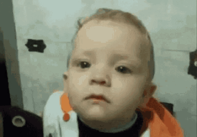 a close up of a baby making a sad face .