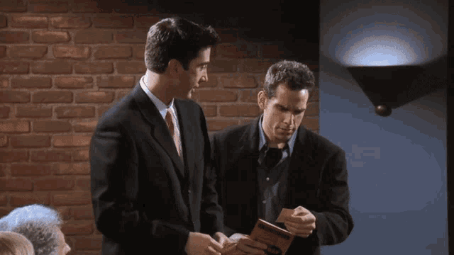 two men in suits are standing next to each other